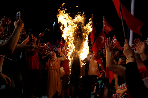 Supporters of Turkish President Tayyip Erdogan shout slogans over a burning effigy of U.S.-based cleric Fethullah Gulen during a pro-government demonstration at Taksim Square in Istanbul, Turkey, July 20, 2016. REUTERS/Ammar Awad