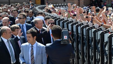 Escorted by an army of guards Erdogan is greeting the public from behind dividers.